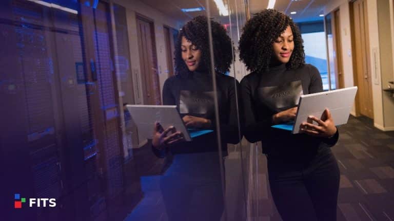 Two colleagues with laptops in a server room corridor